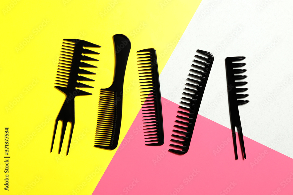 Set of black combs on color background, flat lay