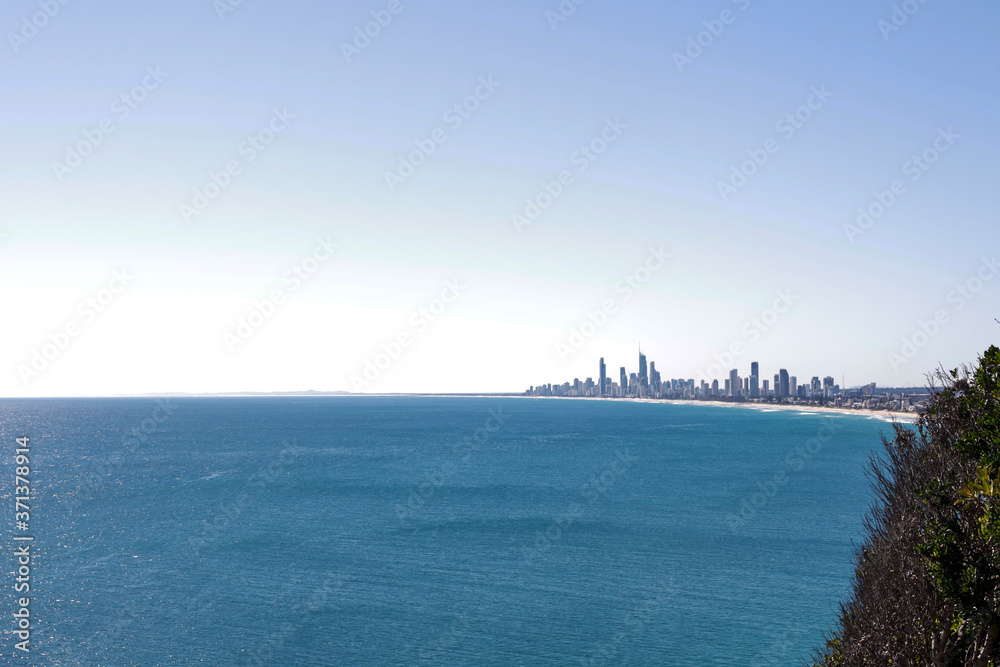 Scenic view of sea and big city against sky