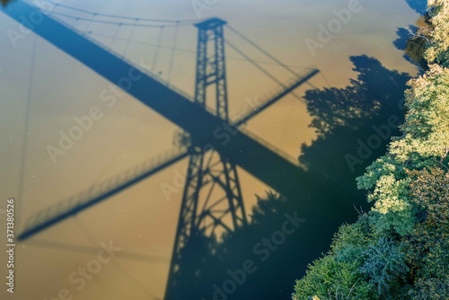 shadow falls on the surface of the river from a suspension bridge over the Teterev River. Zhytomyr. Ukraine photo