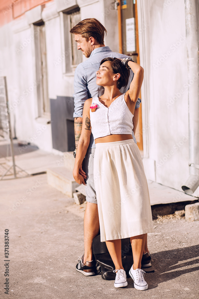 Naklejka premium Woman and man standing back to back near building