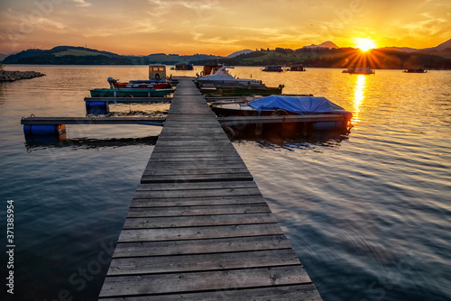 Colorful sunset on lake Liptovska Mara, Slovakia. Boats in port