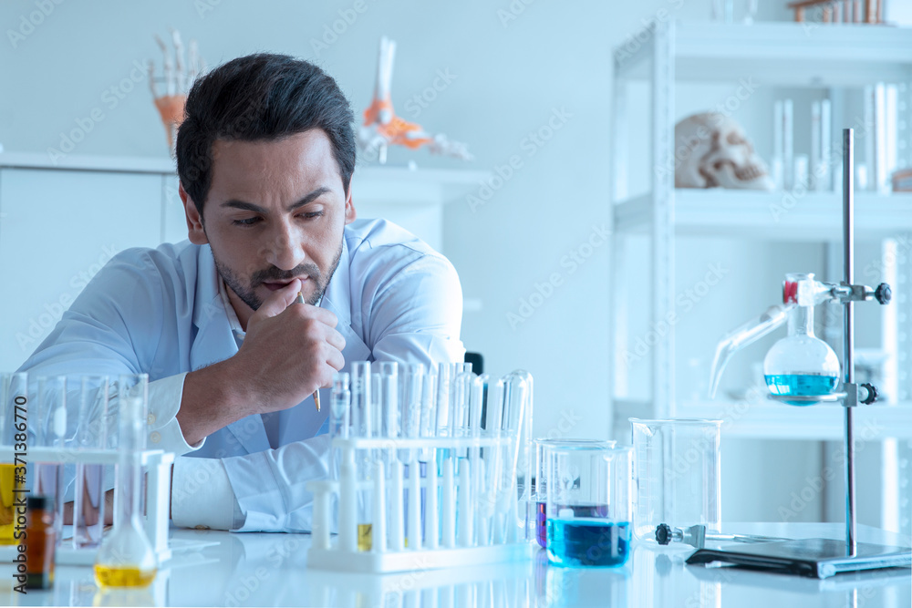 Attractive scientist medical worker with sample test tube at laboratory , doing a analysis in a laboratory doing research to create a vaccine and development Attractive scientist medical worker with sample test tube at laboratory , doing a analysis in a laboratory doing research to create a vaccine and development