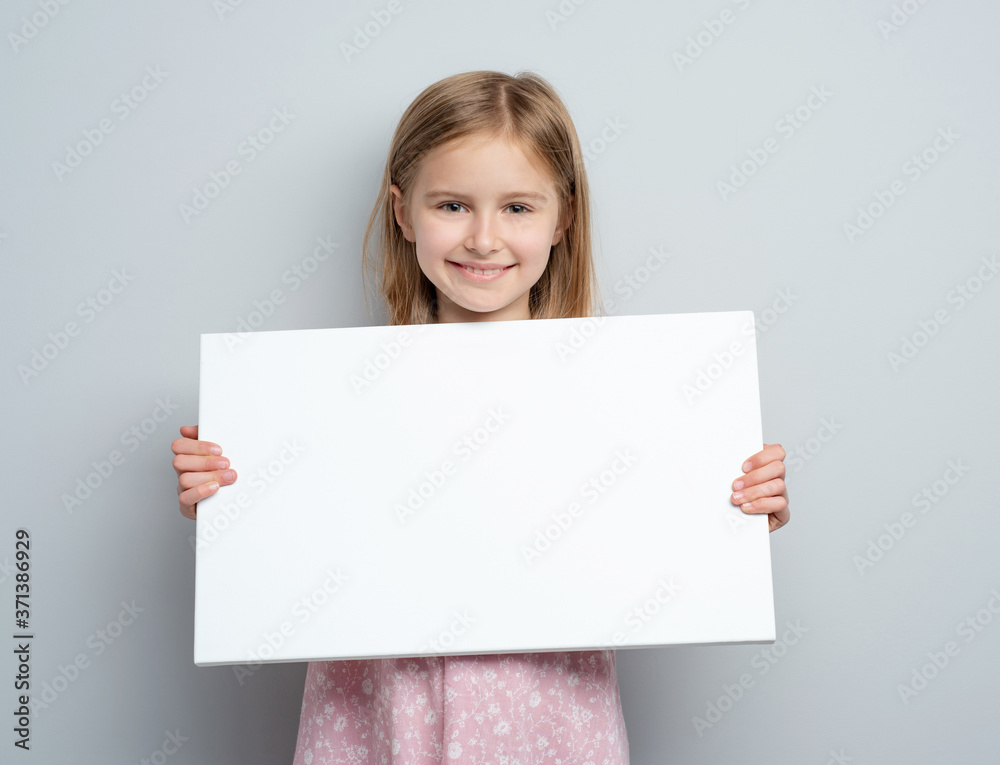 School girl holding horizontal blank white poster School girl holding horizontal blank white poster