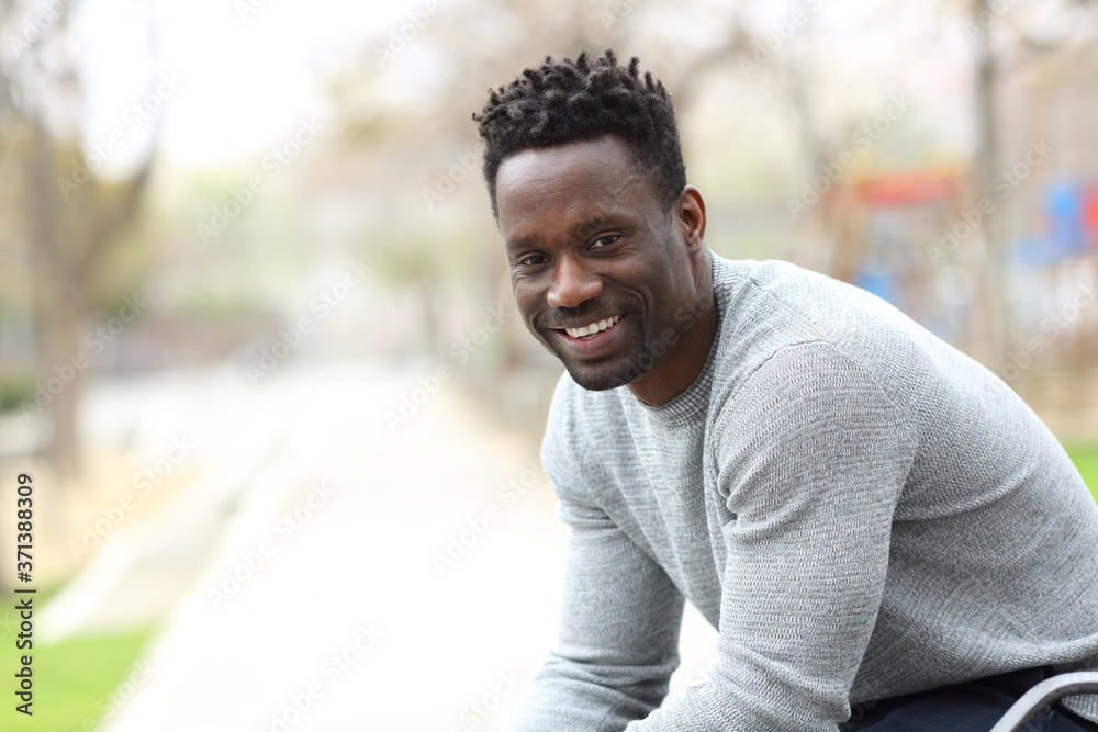 Happy black man posing looking at camera on a park Happy black man posing looking at camera on a park