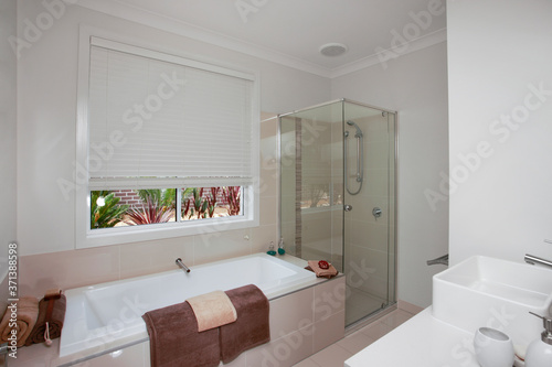 A white bathroom with brown bath towels