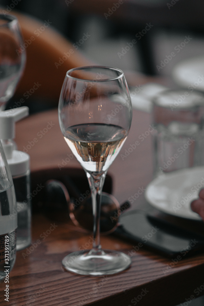 Glass of white sparkling wine at a summer tasting in the hand of a model.