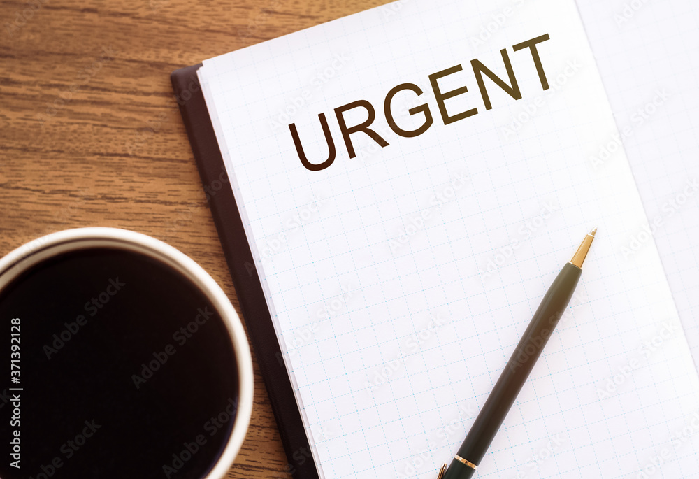 URGENT text on notebook on table with coffee. for design URGENT text on notebook on table with coffee. for design
