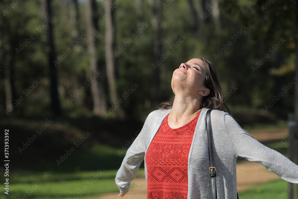 Satisfied woman breathing fresh air in the forest Satisfied woman breathing fresh air in the forest