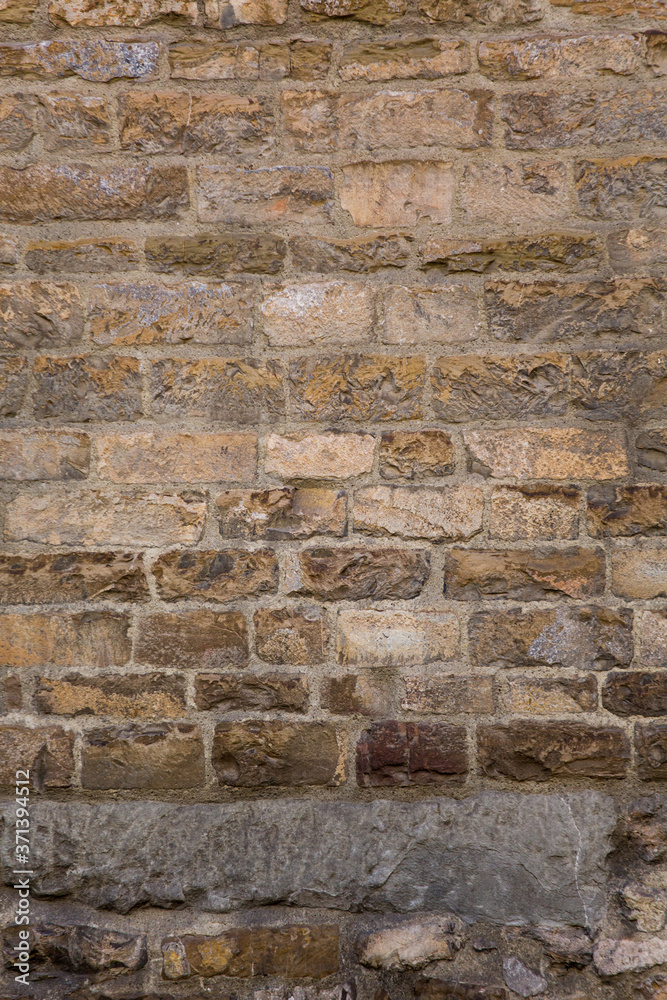 Retro brick wall. Masonry or brickwork of weathered antique architecture construct. Texture or background. Vertical format.