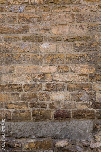 Retro brick wall. Masonry or brickwork of weathered antique architecture construct. Texture or background. Vertical format.