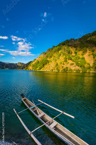 Ambuklao Dam and lake, in Benguet, Philippines. A small fishing boat is docked by the shore. photo