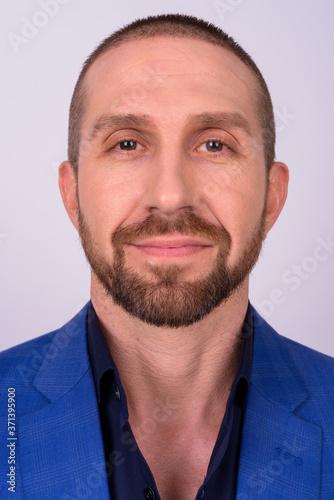 Portrait of handsome bald bearded businessman in suit