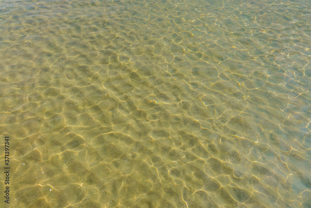 Shoreline bottom of sea, lighted by light of sun. There are shallow water, small playing waves & underwater sand Shoreline bottom of sea, lighted by light of sun. There are shallow water, small playing waves & underwater sand