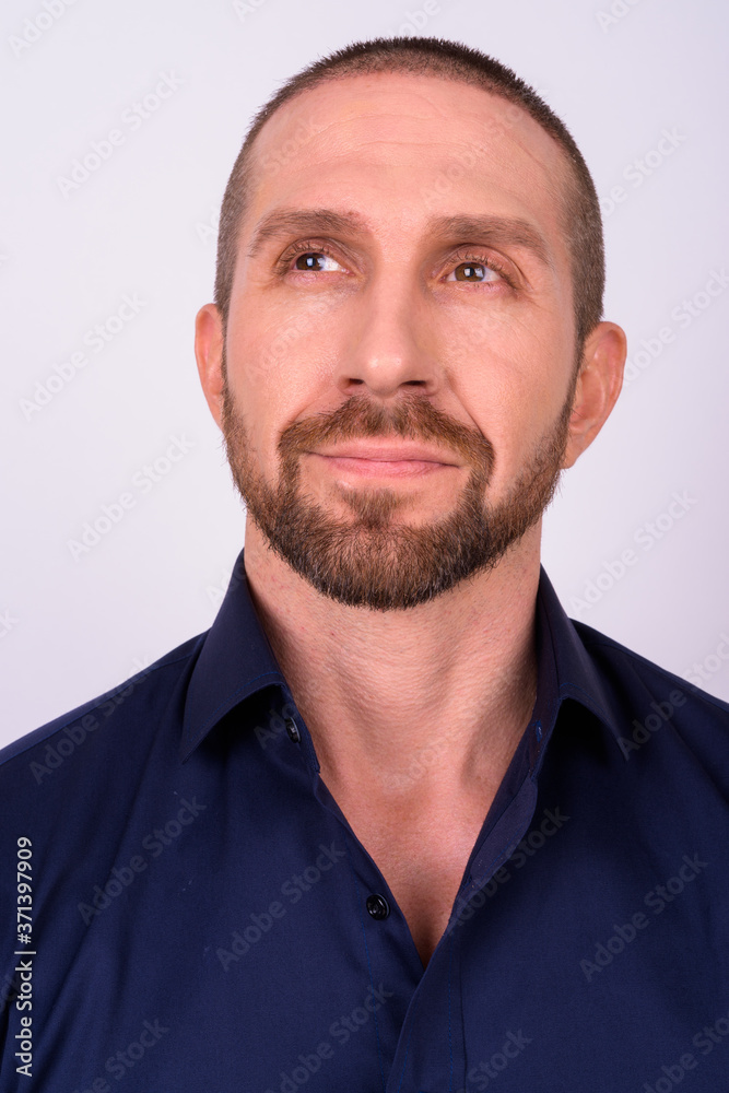 Obraz premium Face of handsome bald bearded businessman thinking and looking up
