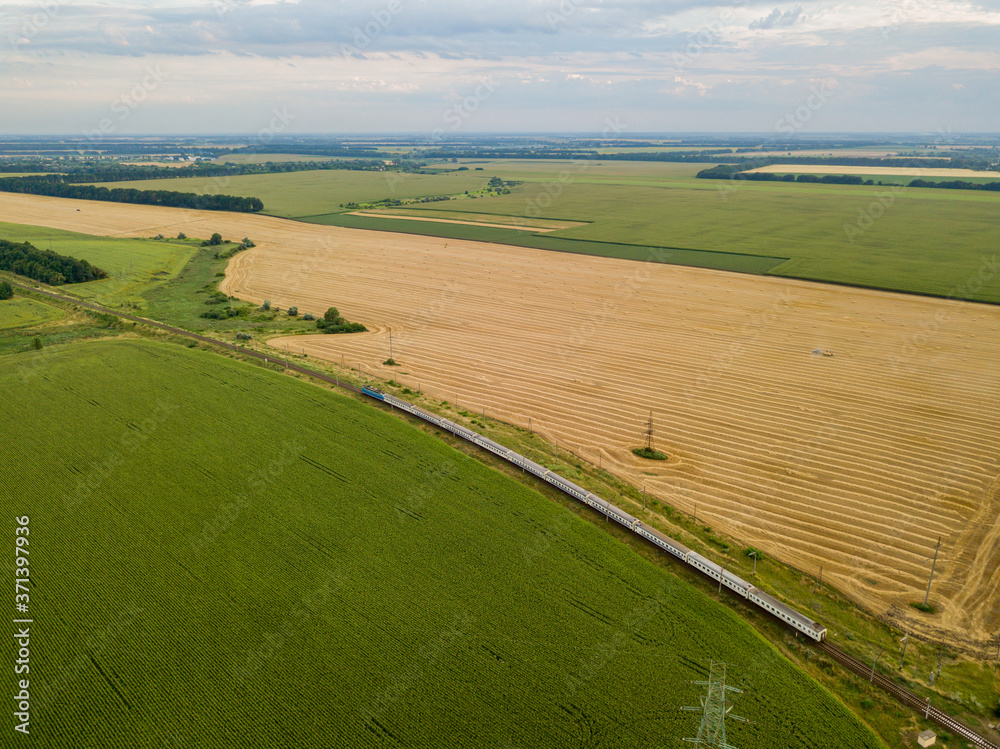 Aerial drone view. The train passes between the fields. Aerial drone view. The train passes between the fields.