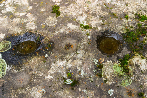 Old stone cups in a rock photo