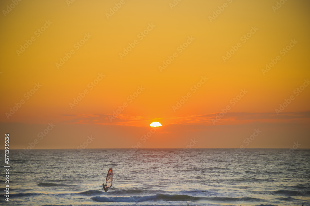 véliplanchiste sur la mer devant un coucher de soleil