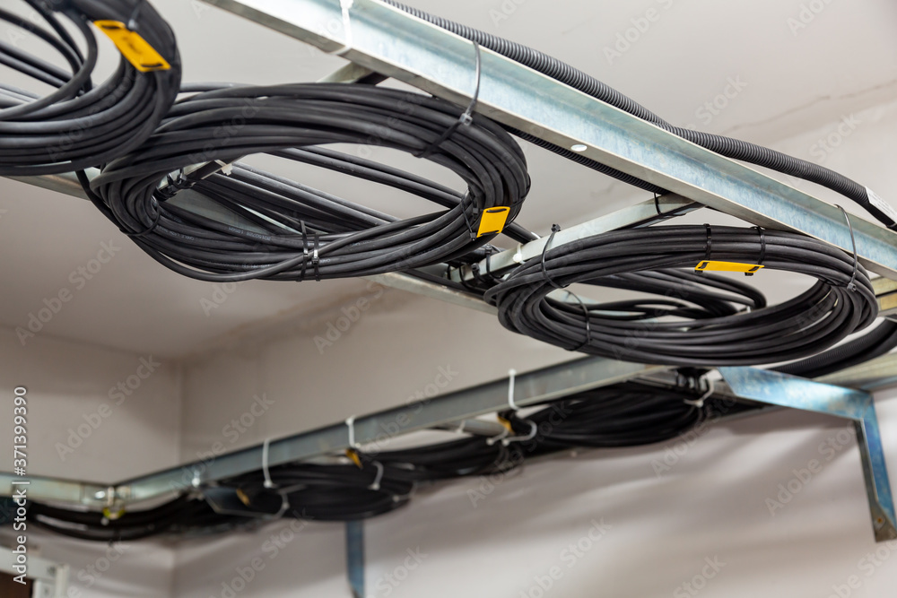 Cable management. Working wires, black cables wound into a coil, a