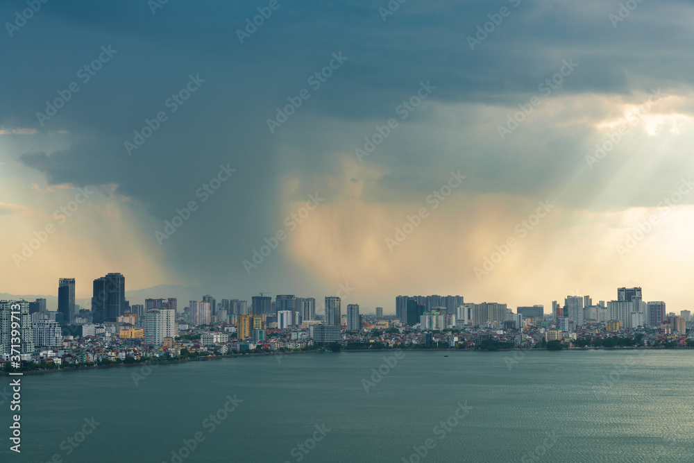 Hanoi cityscape with skyline view during sunset period with dark clouds at West Lake ( Ho Tay ) in 2020