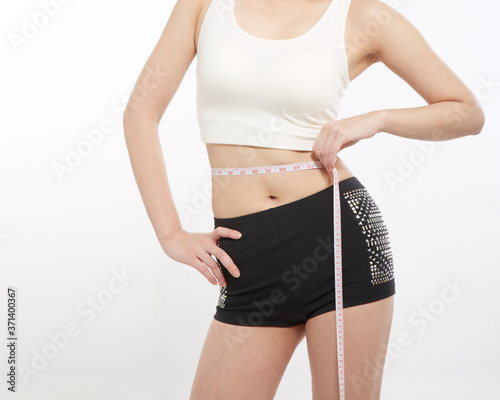 Woman Hand holding measurement tape on waist