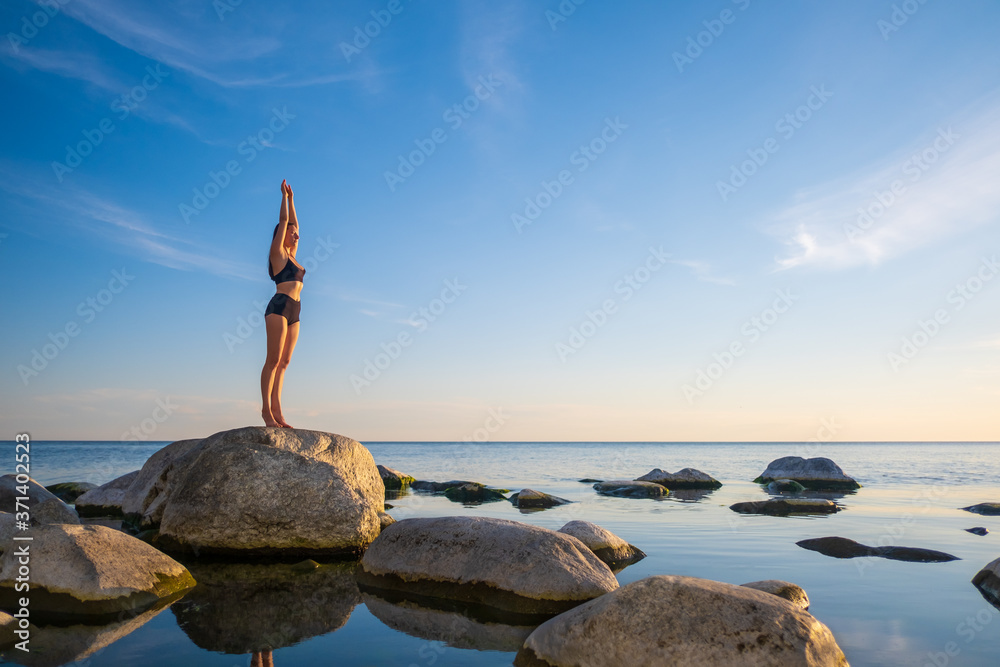 Woman standing on seashore in Mountain pose