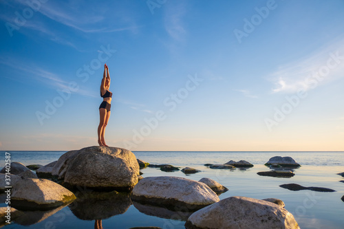 Woman standing on seashore in Mountain pose