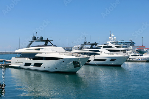Beautiful view of luxury private yachts in the tropical sea on a sunny day. Ships and boats are moored at the pier.. © Alexey