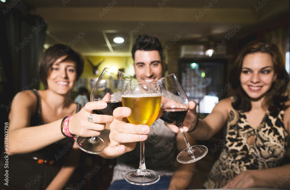 Three friends in restaurant with alcohol cups making toast to the view