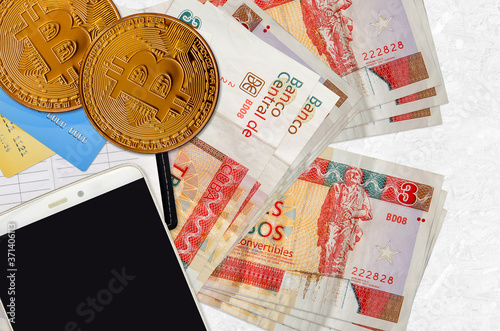 3 cuban pesos convertibles bills and golden bitcoins with smartphone and credit cards. Cryptocurrency investment concept. Crypto mining or trading photo