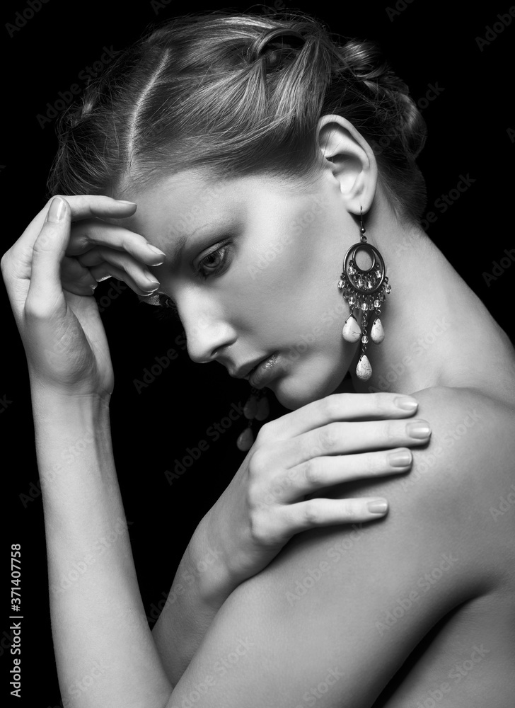 Black and white portrait of young beautiful woman on black