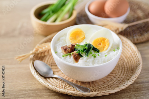 Asian food, Rice soup with boiled egg, grilled mushroom and spinach in a bowl on woven rattan sheet