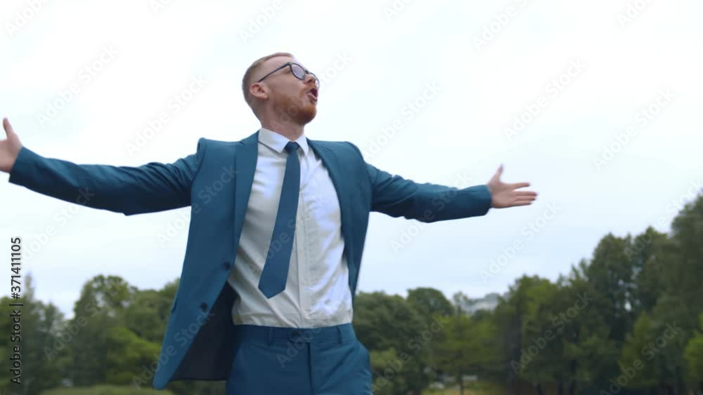 Young successful businessman standing with arms wide open in summer park Young successful businessman standing with arms wide open in summer park