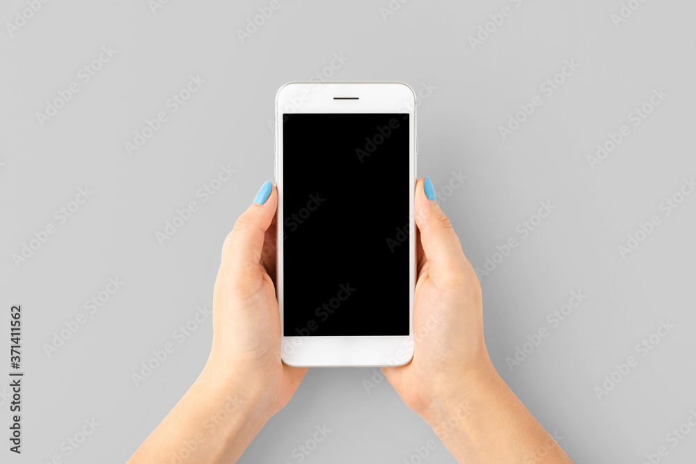 Woman’s hand with blue nails using smart phone with empty screen. Top view. Close up Woman’s hand with blue nails using smart phone with empty screen. Top view. Close up