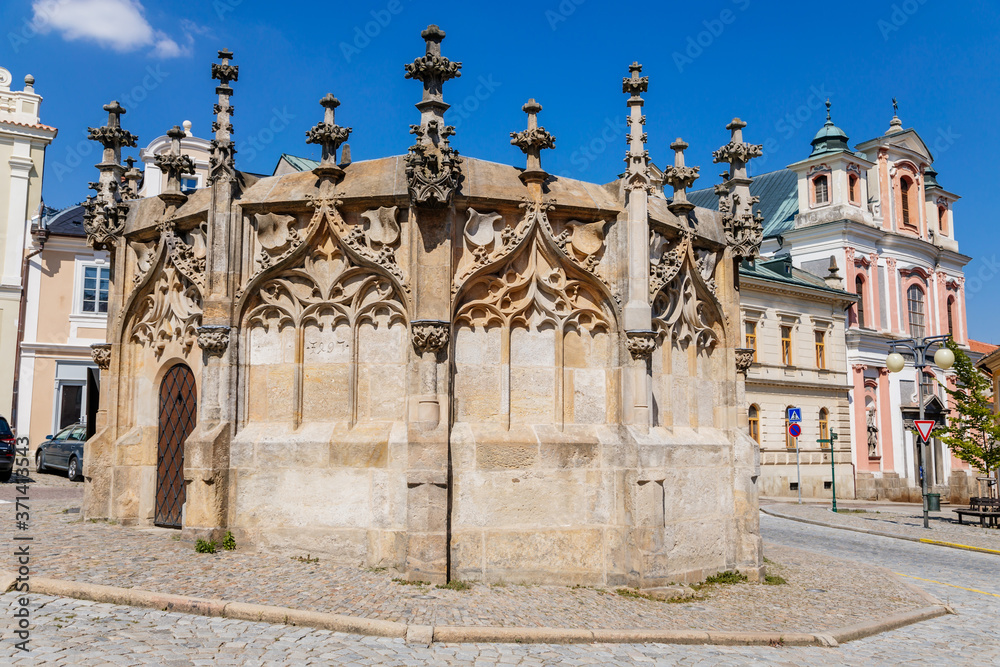 Stone Fountain in historical Town Center with cobblestone road, old style buildings, blue sky, Kutna Hora, Central Bohemian Region, Czech Republic