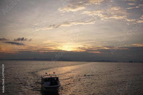 Beautiful sunset over sea with a small boat, Thailand © Hirotsugu