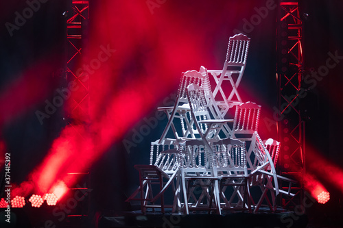 Pyramid of white chairs on stage