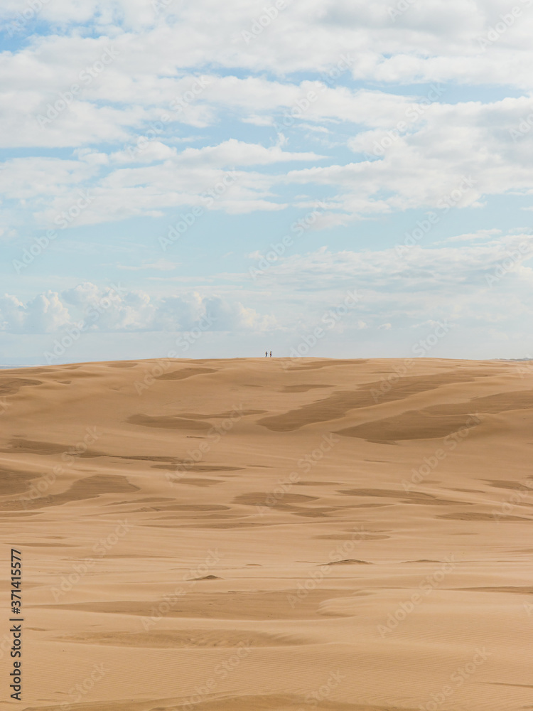 Two people at the distance on the desert.