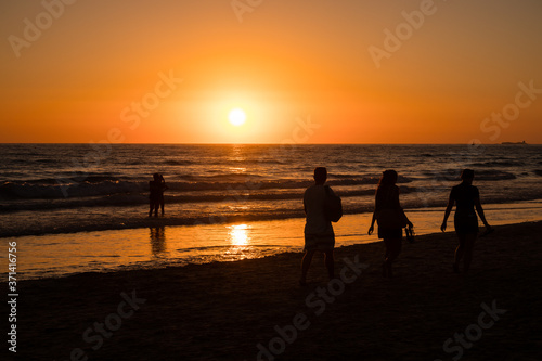 Silhouettes of people taking photos at sunset on the beaches of Cadiz  Spain