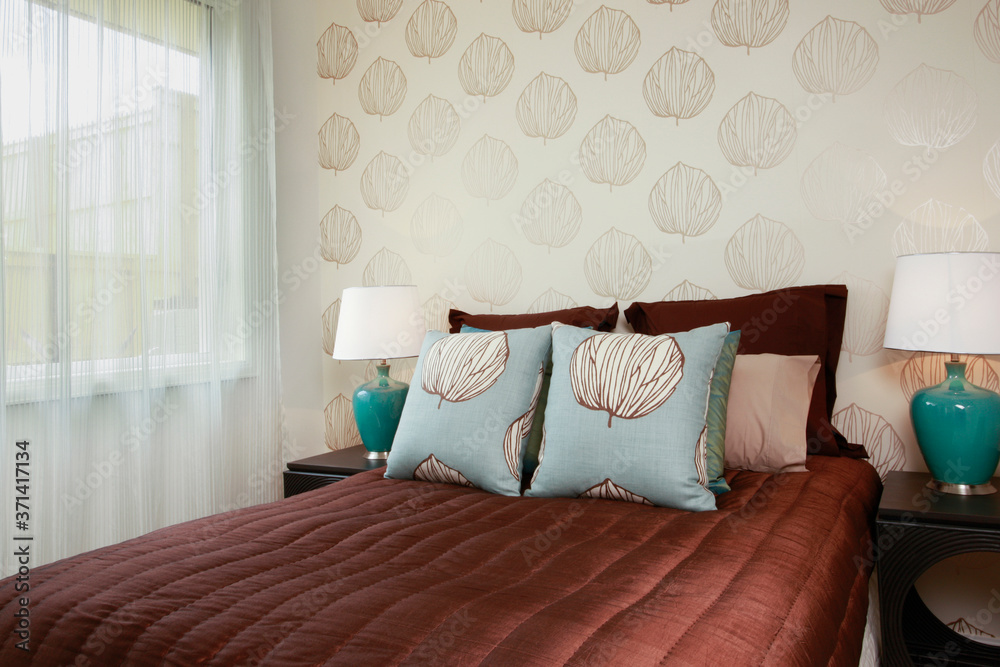 A brown bed linen and aqua pillows