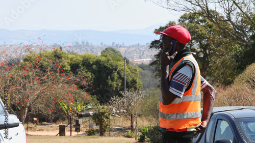 Car guard wearing reflective vest, talking on the mobile phone South Africa 