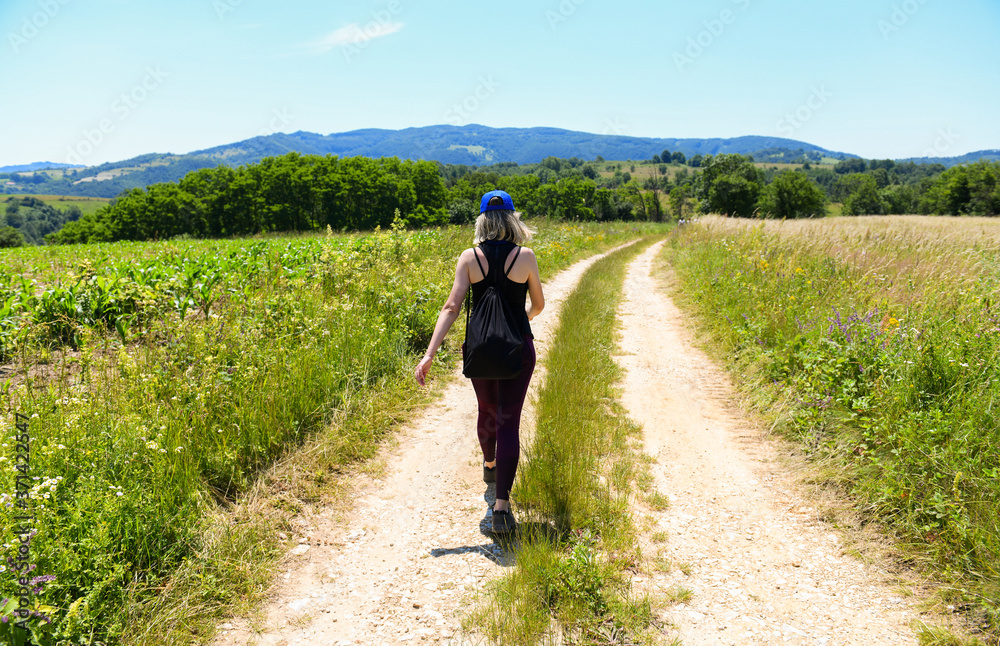 Girl outdoors enjoying nature on the field. On the road