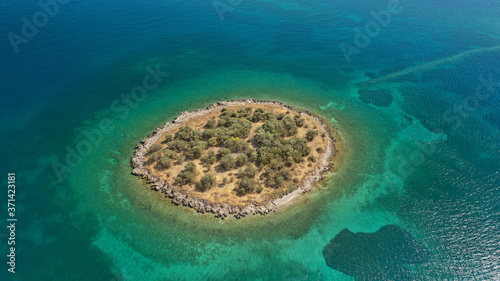 Aerial drone photo of small islet of Agios Konstantinos with small landmark church next to famous city of Itea, Fokida, Greece