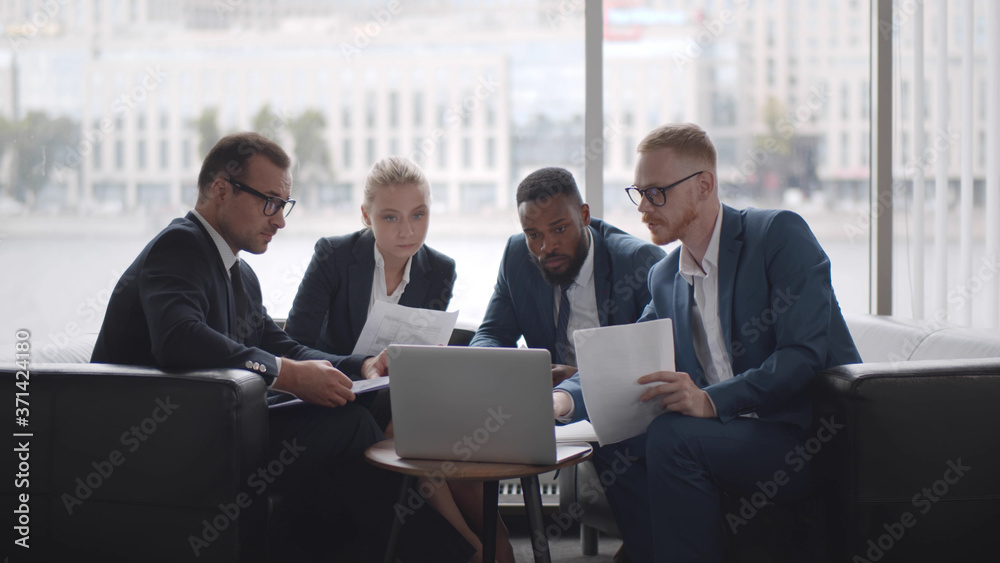 Successful multiethnic business team working on project during work break. Successful multiethnic business team working on project during work break.