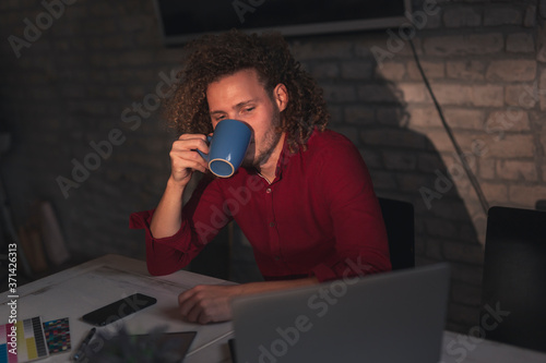 Man drinking coffee and working in an office