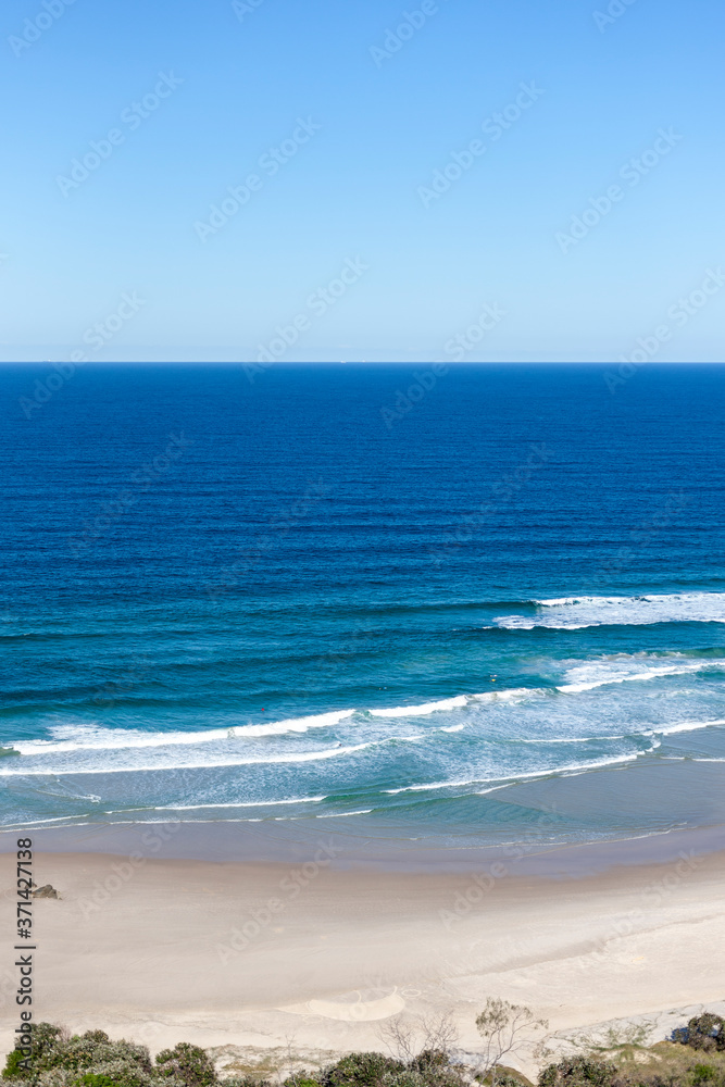 Tropical sandy beach with foamy sea waves