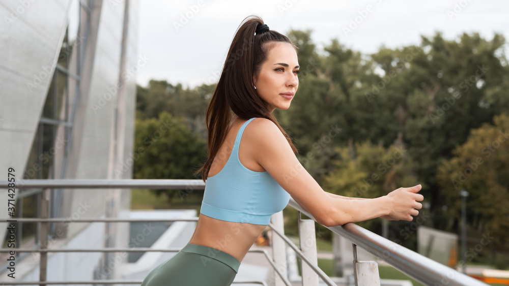 Fitness woman in sportswear rests after an outdoor fitness workout