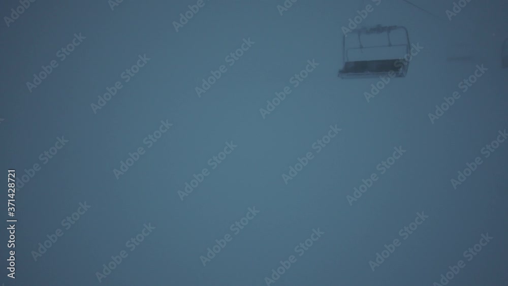 The peak of the mountain is where the ski lift is in the fog. The peak of the mountain is where the ski lift is in the fog.