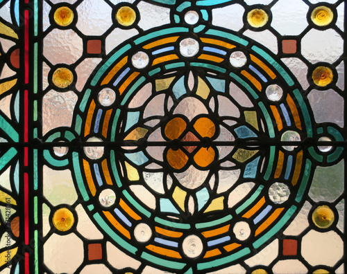 multicolored stained glass window with a flower pattern in a circle