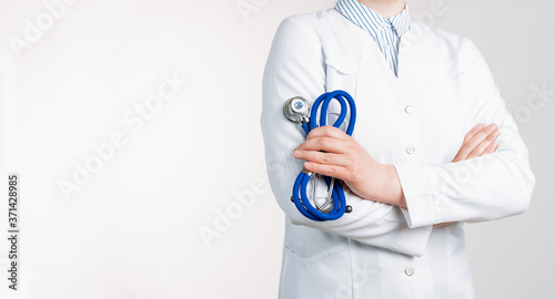 Cropped view of Woman Doctor in uniform standing and holding a stethoscope. Copy space