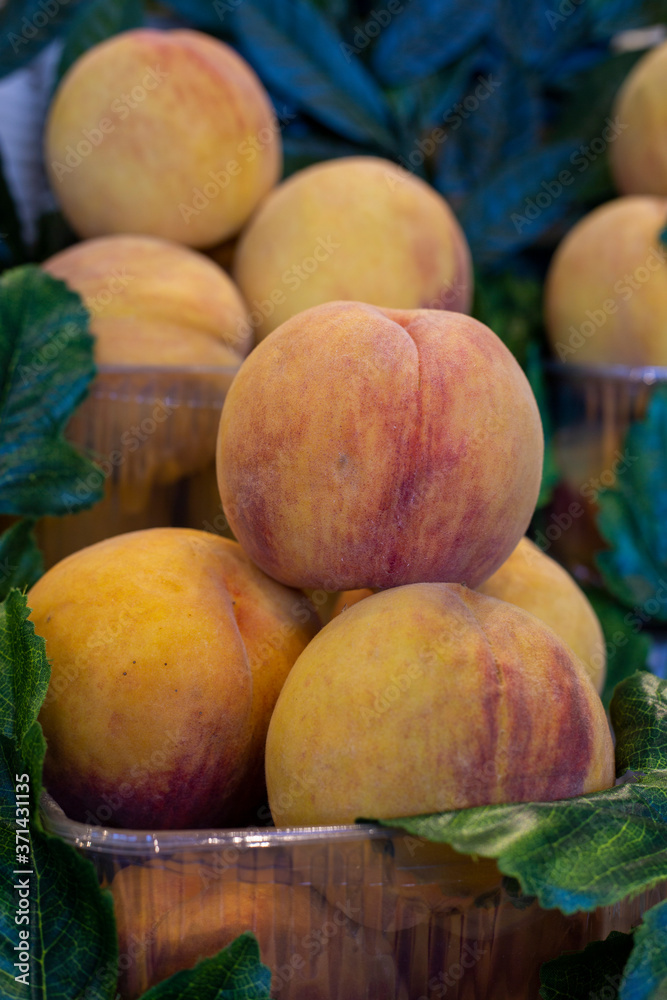 organic peaches ready for sale on the greengrocer counter